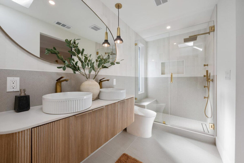 modern bathroom floating vanity double sink glass shower Modern bathroom with wood fluted floating vanity, double vessel sinks, and glass shower enclosure.